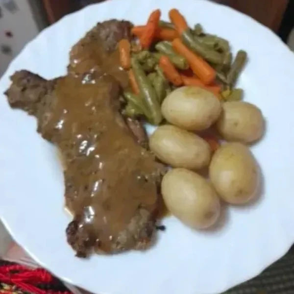 Foto original de un plato de carne con verduras y patatas